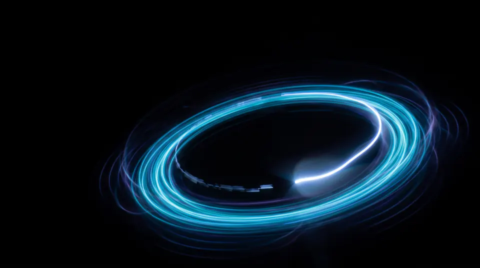 A closed ring of cyan light with one dim broken segment being bridged by a brighter filament.